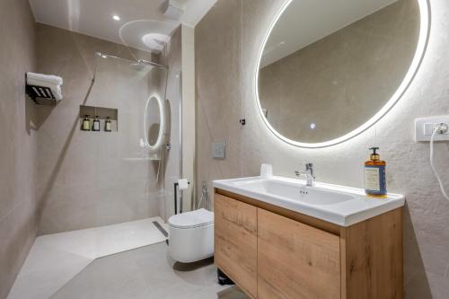 a bathroom with a sink and a toilet and a mirror at Ulin Boutique Hotel in Borsh