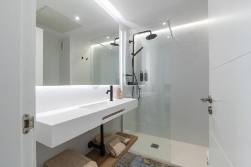 a white bathroom with a sink and a shower at Leo San Bruno in Isla Canela