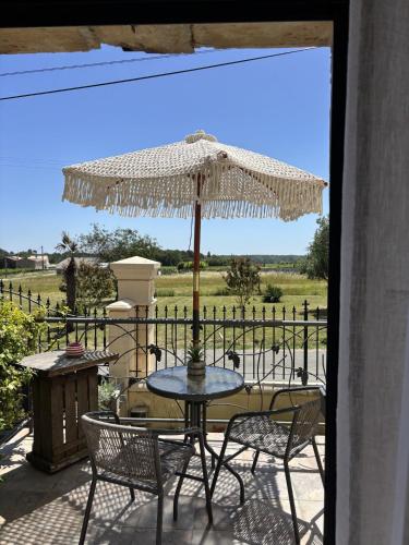 a table and chairs with an umbrella on a patio at Le Relais de la Chouette in Berson
