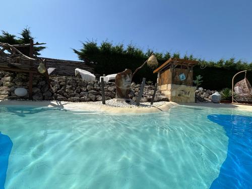 a swimming pool with a water fountain in a yard at Le Relais de la Chouette in Berson