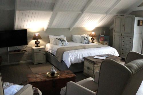 a bedroom with a large bed and a living room at Matopos Loft in Stilbaai-Wes