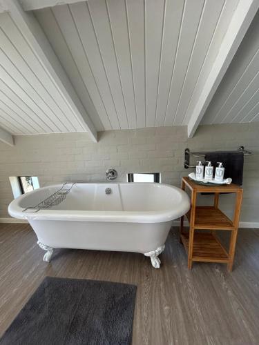 a large white bath tub in a room at Matopos Loft in Stilbaai-Wes