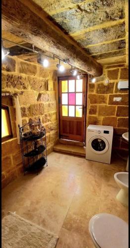 a stone room with a stove and a window at Mithna farmhouse in Għarb