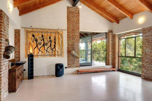 an empty living room with a brick wall at Casa Centomila Volte Benvenuti in Tigliole