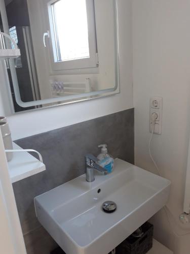 a bathroom with a white sink and a mirror at Hausboot MeerZeit in Wangerland