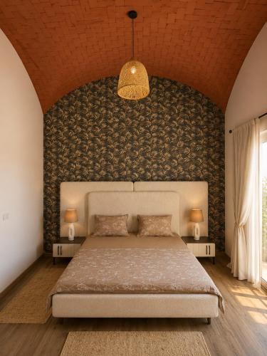 a bedroom with a large bed and a wall at Kefia house in Hammamet Nord
