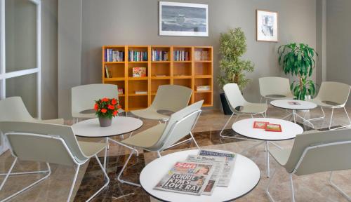 a room with tables and chairs and a book shelf at Aparthotel Cye Holiday Centre in Salou