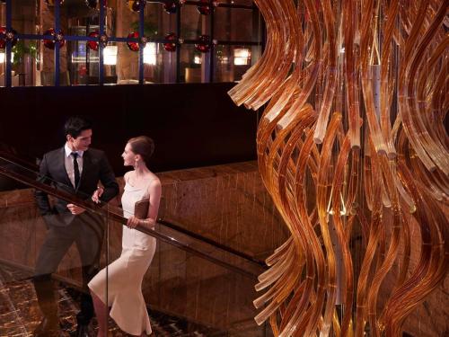 a man and a woman standing on a rail at Fairmont Beijing in Beijing