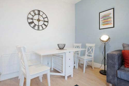 a white table and chairs in a room with a clock at Sunderland 3BR Retreat Sleeps 6 by Stay With Us in Pallion