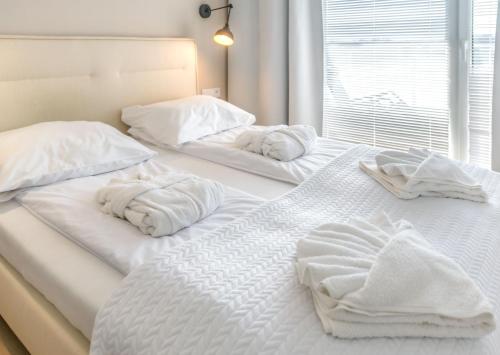two white beds with towels on them in a room at Happy Land Aqua Polanki B407 in Kołobrzeg