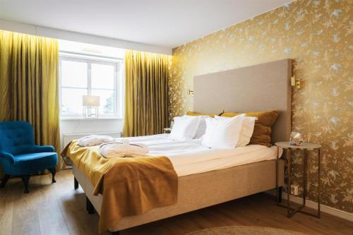 a bedroom with a large bed and a blue chair at Best Western Hotell Lerdalshoejden in Rättvik