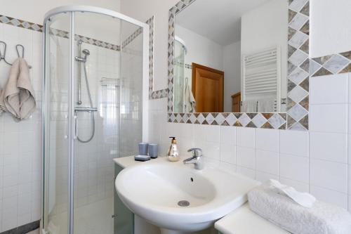 a white bathroom with a sink and a shower at Alla Loggia dell'Imperatore in Levico Terme