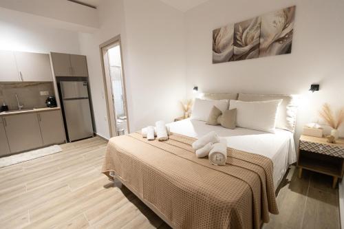 a bedroom with a large bed with towels on it at Elysian Studios in Mavrovouni