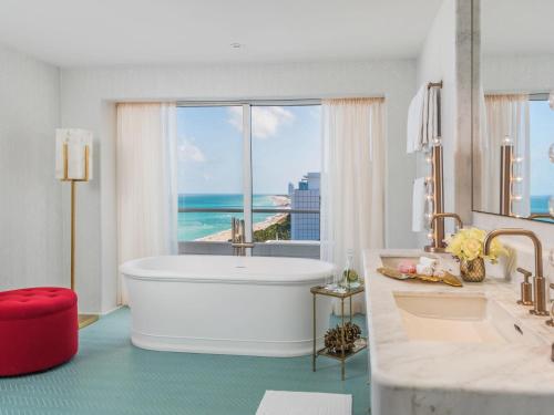 a bathroom with a tub and a view of the ocean at Faena Miami Beach in Miami Beach