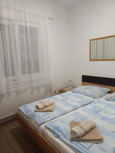 a bedroom with two beds with towels on them at Budai Garden House in Hévíz
