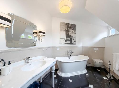a white bathroom with a sink and a toilet at Villa Boddenwacht in Ahrenshoop