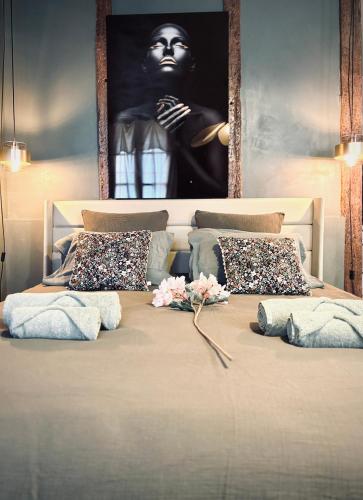 a large bed with pillows and a picture on the wall at La Suite Archevêché by Collection Signature - Hypercentre Albi - Parking inclus in Albi