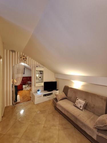 a living room with a couch and a television at MÐM Duplex Apartment in Podgorica