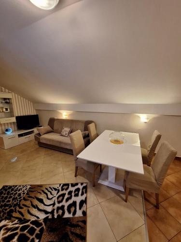 a living room with a white table and a couch at MÐM Duplex Apartment in Podgorica