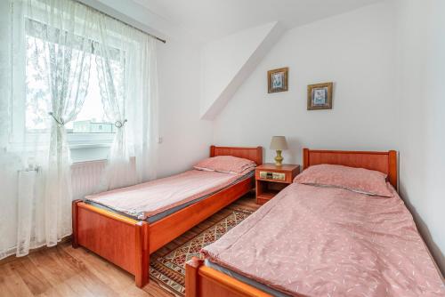 two beds in a room with a window at KRAB 2 in Rewal