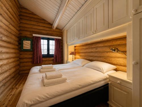 a bedroom with a large bed in a log cabin at Large, cozy, and spacious cabin in Geilo, Kikut in Geilo
