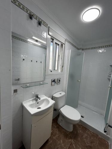 a bathroom with a toilet and a sink and a shower at Brisa de Pinares in Barbate