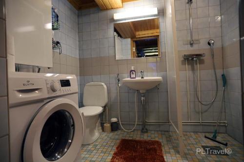 a bathroom with a washing machine and a sink at Holidayhome Sompio in Luosto