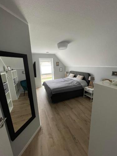 a bedroom with a bed and a mirror at Wangerstrand in Wangerland