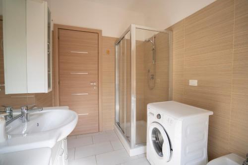 a bathroom with a washing machine and a sink at Villa Chiara Infinity Sea View in Mandaradoni
