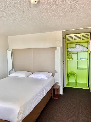 a bedroom with two beds and a green door at Campanile Valence Sud in Valence