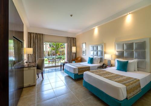 a hotel room with two beds and a balcony at Tropitel Sahl Hasheesh in Hurghada