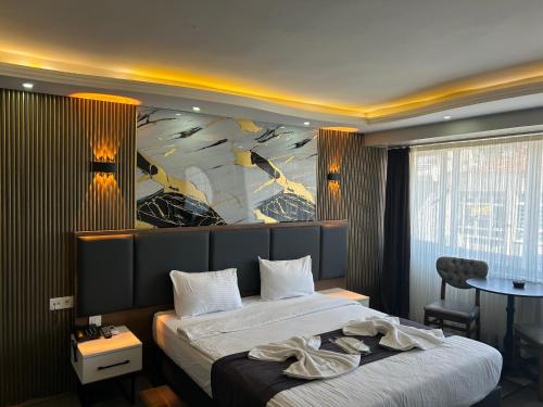 a bedroom with a large bed with a painting on the wall at Lizbonia Suit Otel in Istanbul