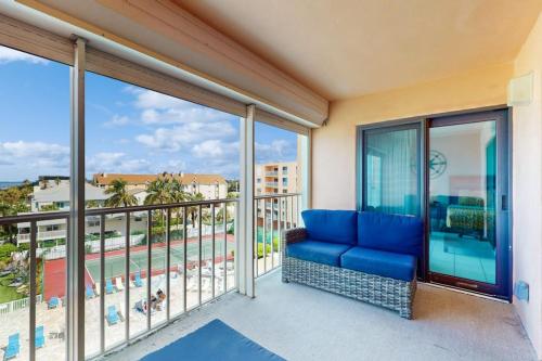 a living room with a blue couch on a balcony at Reef Club 401 in Clearwater Beach