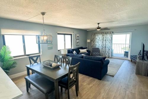a living room with a blue couch and a table at Reef Club 401 in Clearwater Beach