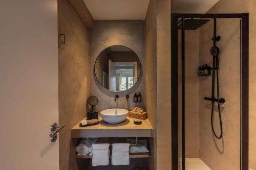 a bathroom with a sink and a mirror and a shower at Masana Algarve, Destination by Hyatt in Albufeira