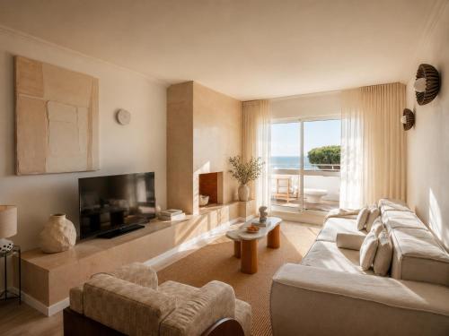 a living room with a couch and a television at Masana Algarve, Destination by Hyatt in Albufeira