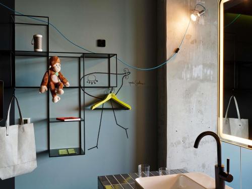 a teddy bear sitting on a shelf in a bathroom at 25hours Hotel Bikini Berlin in Berlin
