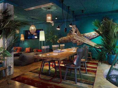 a dining room with a table and a plane on the wall at 25hours Hotel The Trip in Frankfurt