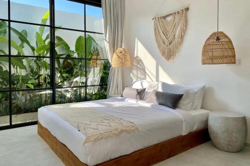 a bedroom with a bed and a large window at The Young Villas - Canggu in Canggu
