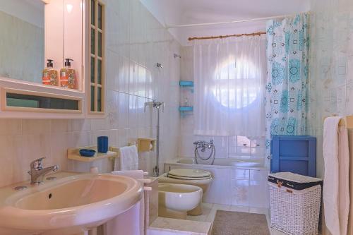 a white bathroom with a sink and a toilet at Passione Mare in Porto Palo