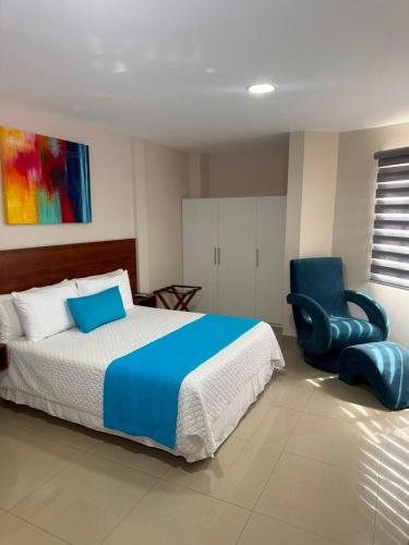 a bedroom with a bed and a blue chair at Marina Breeze hotel in Manta