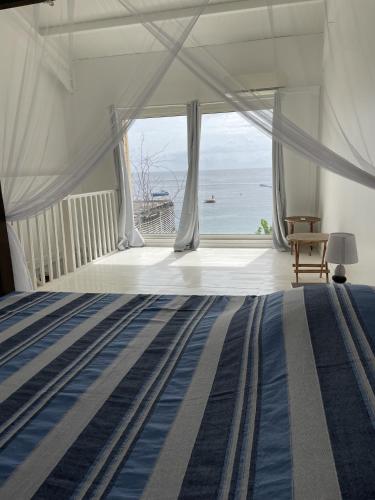 a bedroom with a bed with a view of the ocean at La maison sur la plage in Saint-Pierre