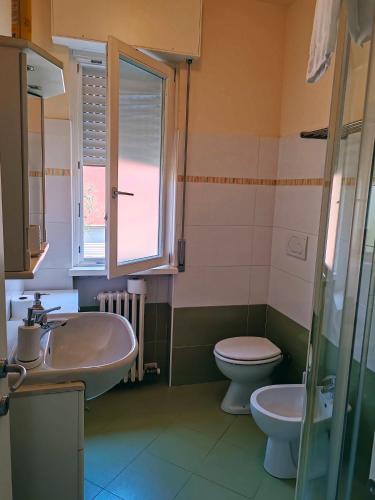 a bathroom with a sink and a toilet and a window at La casa di Viola in Bardolino