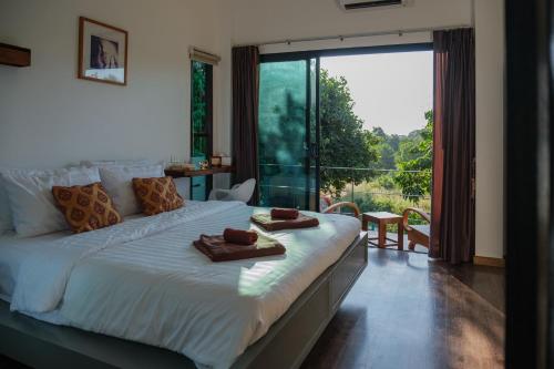 a bedroom with a large bed with two towels on it at Sam Lanta in Ko Lanta
