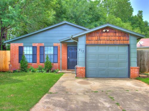 a house with a blue garage in a yard at Oak & Elm 2BR King & Queen Edmond, OK in Edmond