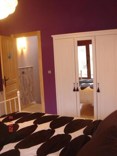 a bedroom with a bed with a black and white comforter at La Cuadrina de Anton in Pajares