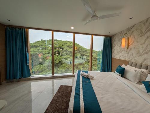 a bedroom with a bed and a large window at The Aspire Hotel Guwahati in Guwahati