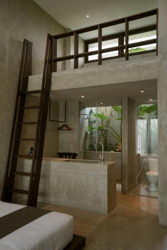 a bedroom with a loft bed and a bath tub at Tibah in Tanah Lot