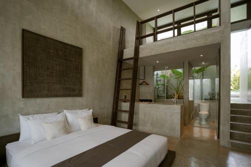 a bedroom with a large bed and a bathroom at Tibah in Tanah Lot