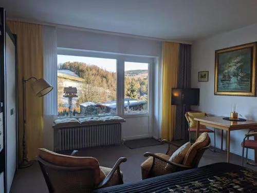 a hotel room with a large window and a desk at Haus Kiel in Altenau